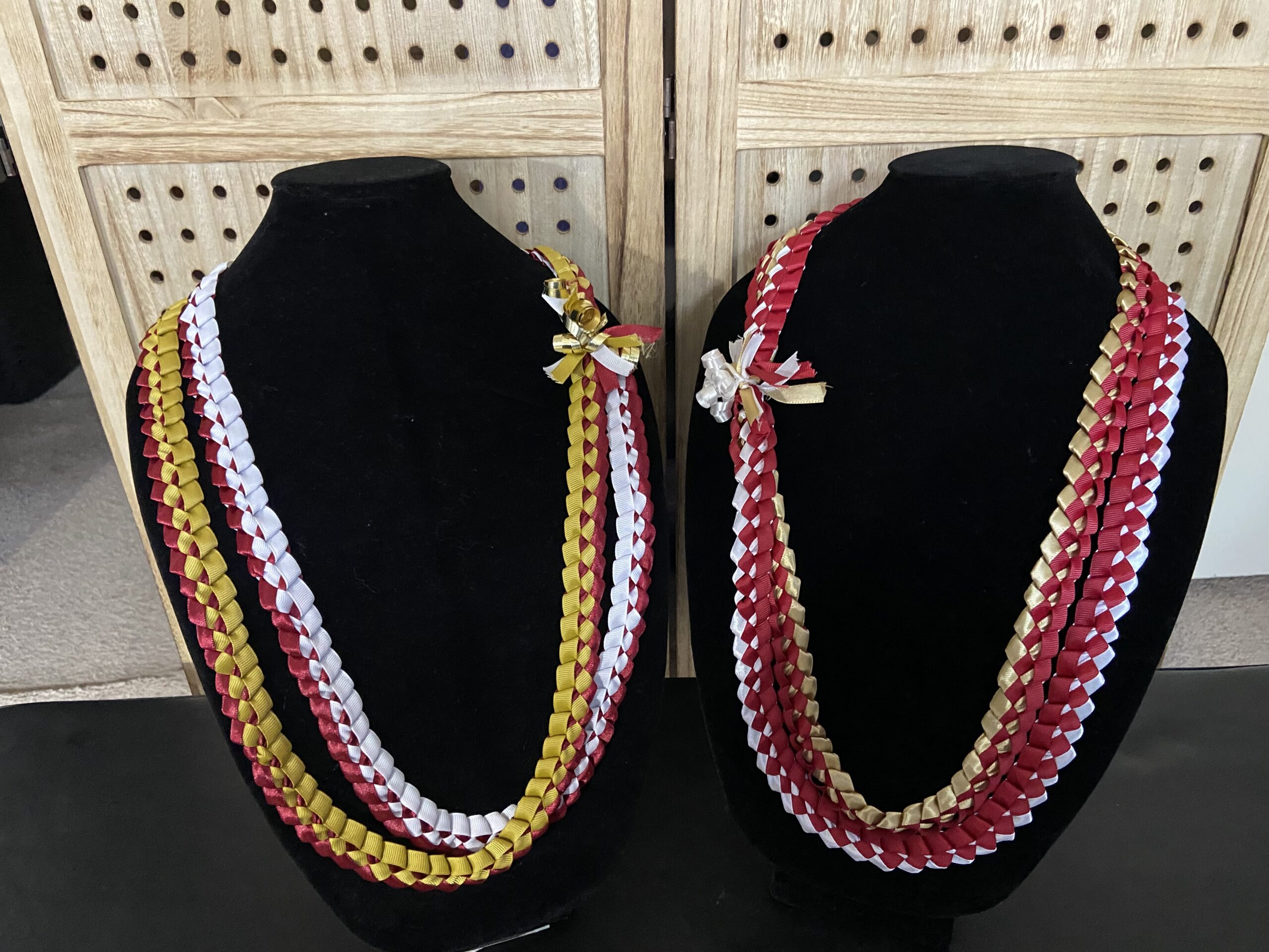 Handmade, colorful leis on necklace display.