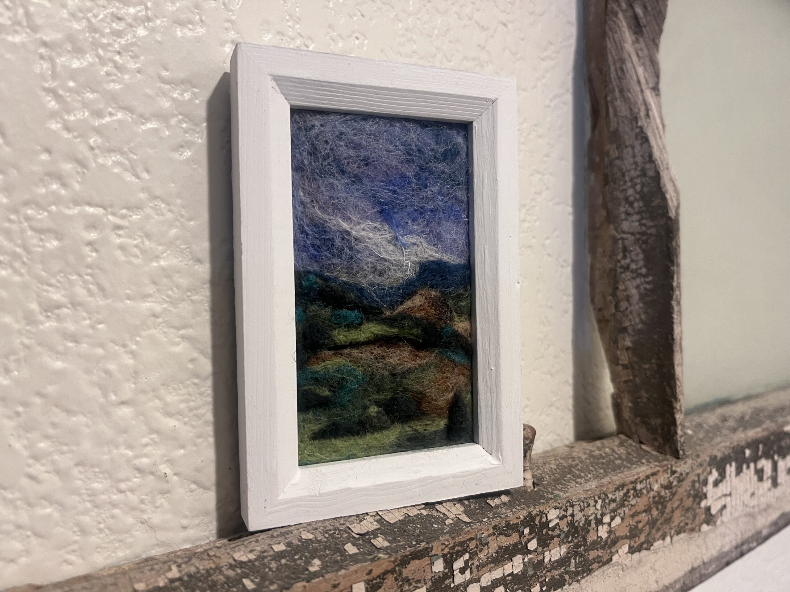 Felted art piece in a white frame