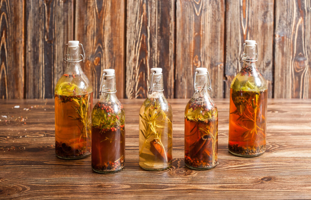 Spices bottled in oil on dark wooden background