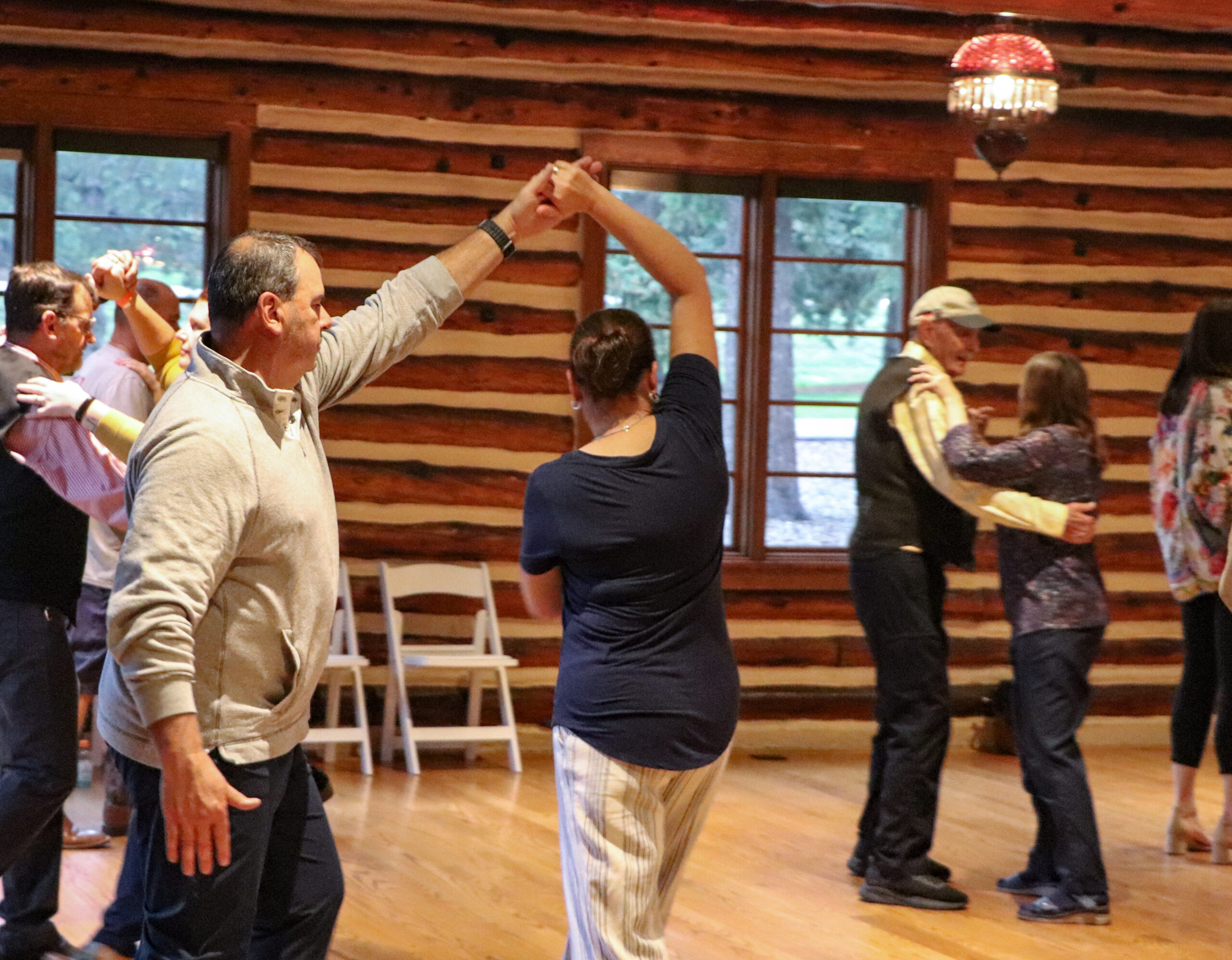 Man and woman practicing ballroom dance surrounded by other couples