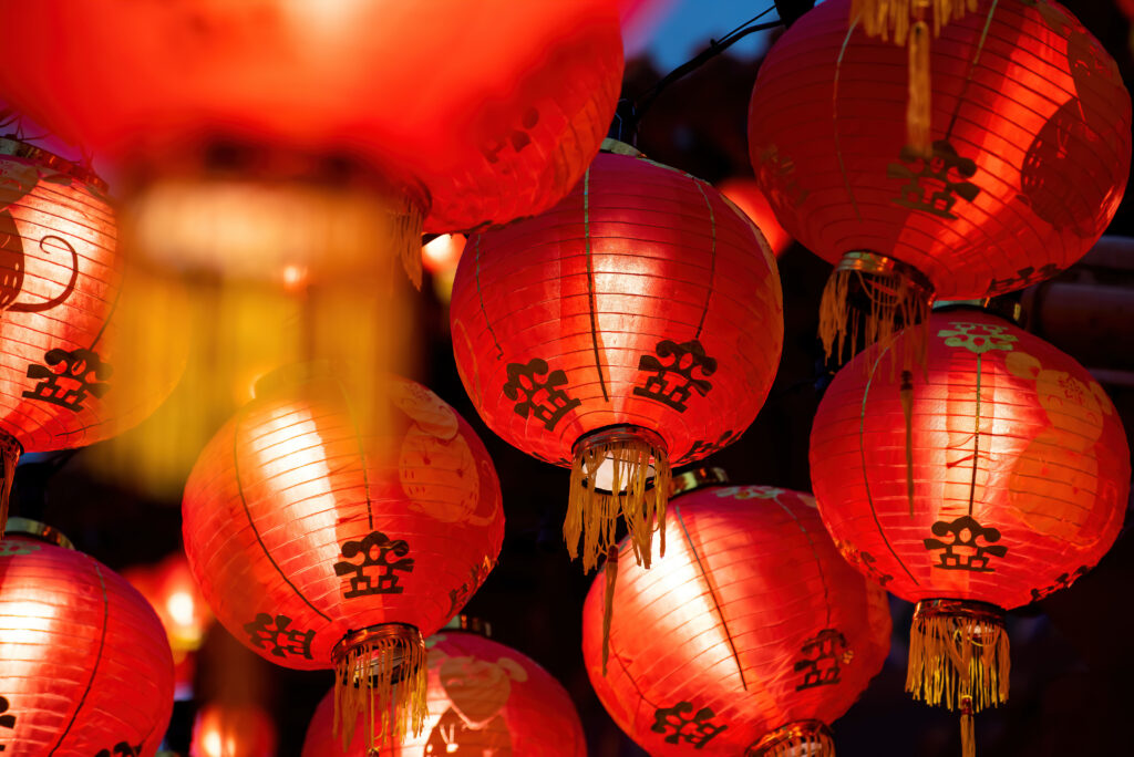 Rows of colorful glowing red Chinese lanterns hanging high across the street during Chinese New Year Celebrations.